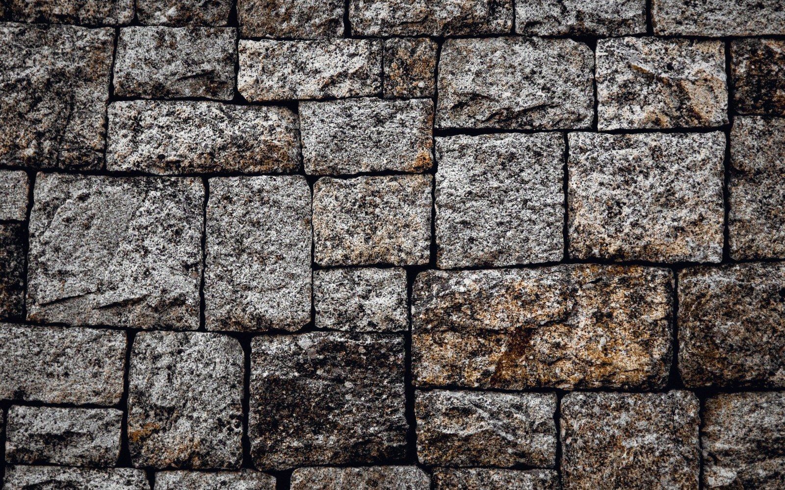 Rectangular granite blocks fitted tightly together in a textured stone wall